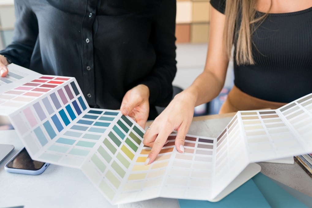 A couple planning their home renovation by choosing paint colours