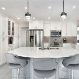 What is a Whole Home Renovation featured image of a remodeled kitchen with white countertops and cupboards